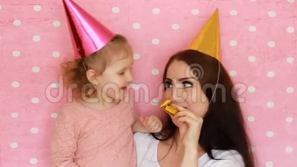 女人和孩子吹角笑着笑着母亲和女儿吹喇叭玩得很开心生日快乐视频的预览图