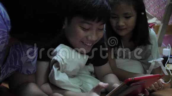 亚洲儿童在家玩平板电脑记录手持式慢速运动在4K在60fps视频的预览图