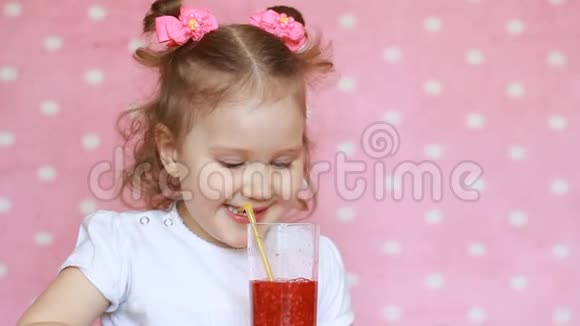 一个快乐的孩子正在用吸管喝冰沙微笑着一个可爱的女孩的特写肖像她喜欢视频的预览图