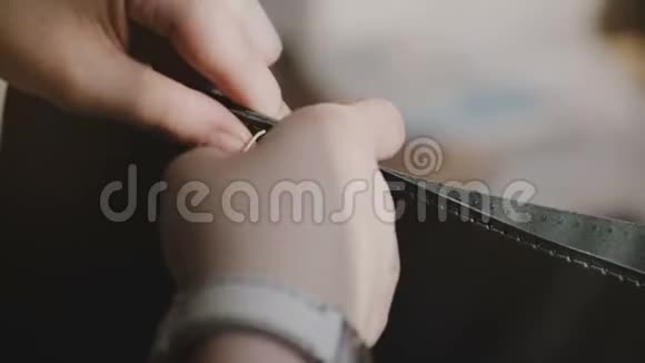 漂亮的特写镜头熟练的专业女性手在缝制过程中用针编手工皮包视频的预览图