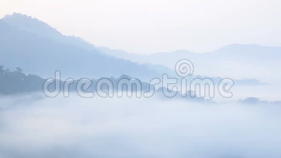 清晨日出时在热带雨林中用杜丽滑块相机拍摄一片雾覆盖的高山景色视频的预览图