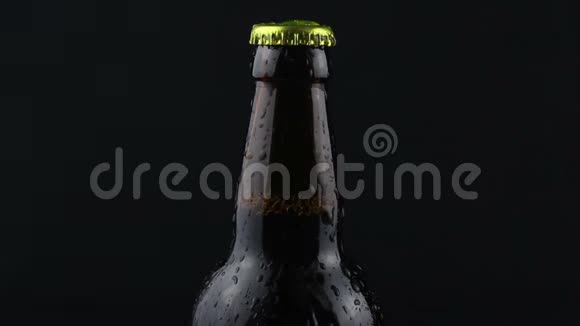 凝结水滴在黑暗的背景下从啤酒瓶中流出一瓶雾蒙蒙的啤酒视频的预览图