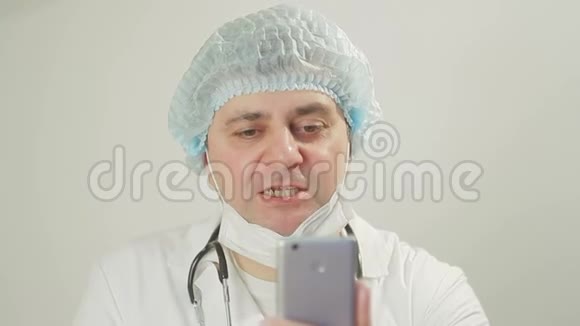 医生的特写通过视频链接与手中的智能手机进行交流视频的预览图