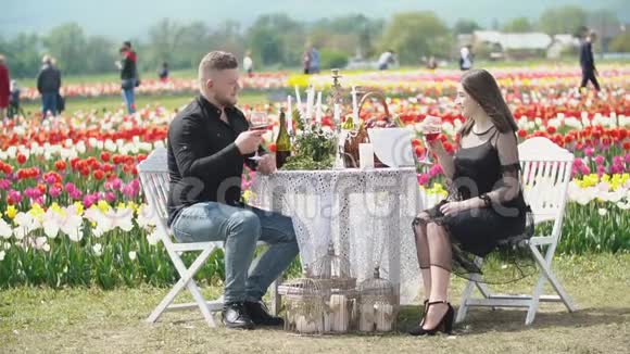 一对年轻夫妇坐在桌边喝酒视频的预览图