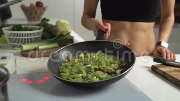 特写的烹饪炒洋葱和芹菜把它们放入热煎锅慢动作视频的预览图
