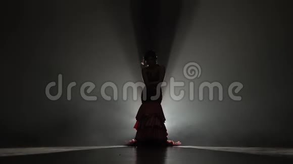 女孩正在和蓖麻一起跳舞她的腿在拽着裙子的尾巴从后面的光烟雾背景视频的预览图