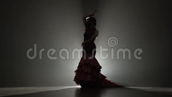 女孩正在和蓖麻一起跳舞她的腿在拽着裙子的尾巴从后面的光烟雾背景视频的预览图