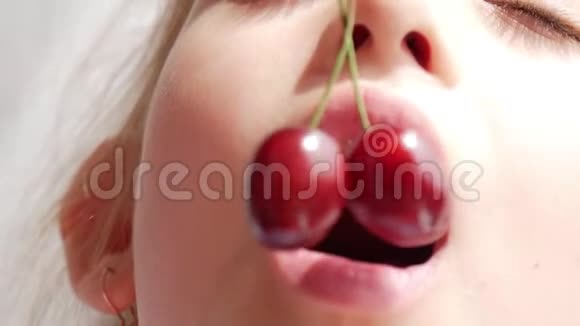 可爱的小女孩吃樱桃关门健康的年轻女孩吃红樱桃视频的预览图