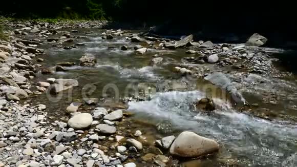在山上的小溪岩石之间冰冷清澈的溪流视频的预览图