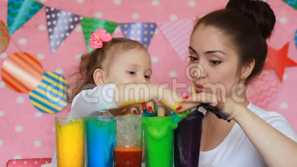 妈妈和孩子正在做一个彩色泡沫的实验生日庆祝活动脏手在油漆里研究颜色视频的预览图
