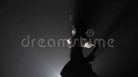 弗拉门戈女孩正在和蓖麻一起跳舞她的腿在拽着裙子的尾巴从后面的光吸烟视频的预览图