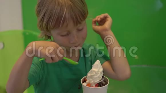 一个小男孩正在吃美味的冷冻酸奶冰淇淋视频的预览图