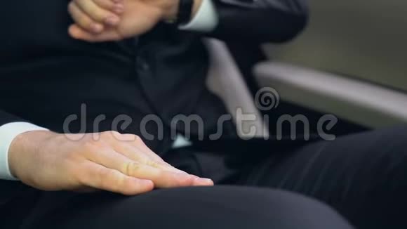 穿西装的男人看着手表紧张地用手敲着膝盖快点视频的预览图