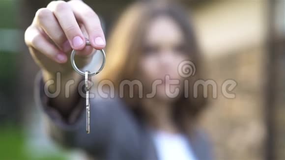 无法辨认的年轻女子展示新房子的钥匙视频的预览图