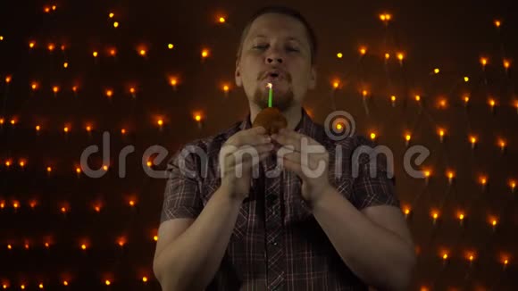 一个红胡子的年轻人吹灭蜡烛咬他的生日蛋糕视频的预览图