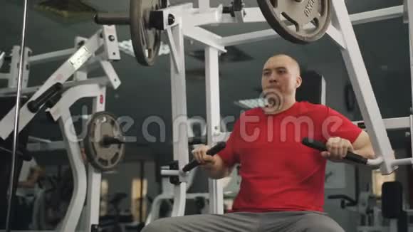 一个有运动身材的人在健身房的模拟器上做运动视频的预览图