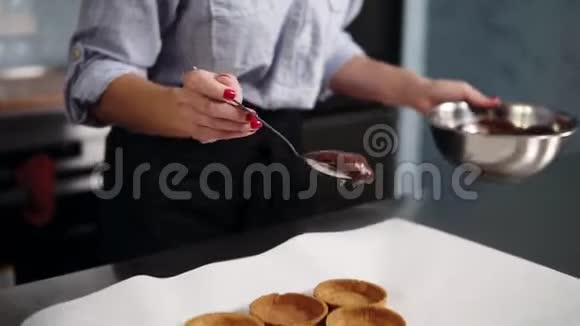 用勺子用巧克力奶油填充烤酒石工作台面用白纸覆盖视频的预览图