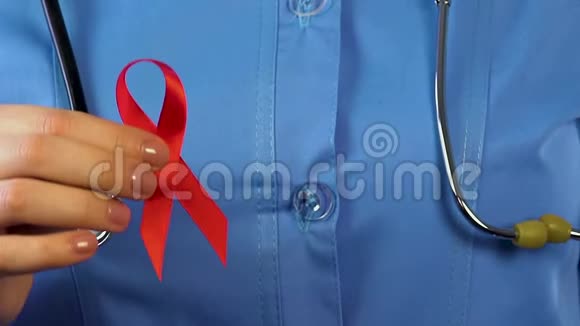 女医生手里拿着红丝带和避孕套预防艾滋病毒艾滋病视频的预览图