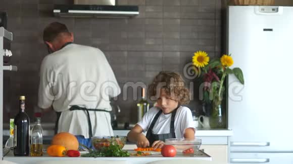那个小学生帮他爷爷准备晚餐男孩切菜做沙拉然后把它们放在一个干净的地方视频的预览图