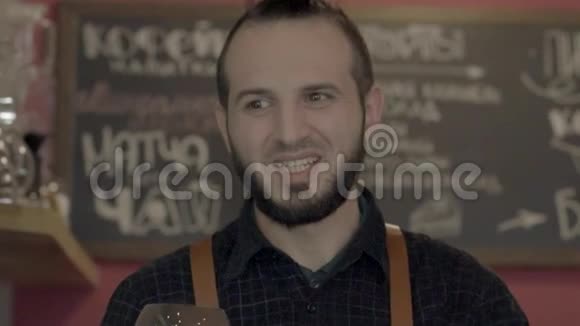 一个微笑的年轻咖啡师给咖啡慢动作视频的预览图