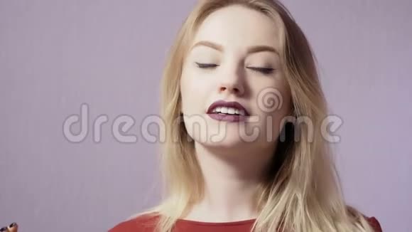 有着紫色背景的化妆和紫色嘴唇的快乐女孩视频的预览图