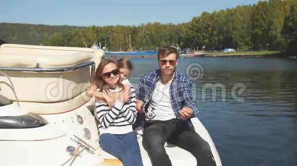 家人和女儿一起在湖边的帆船上度假视频的预览图