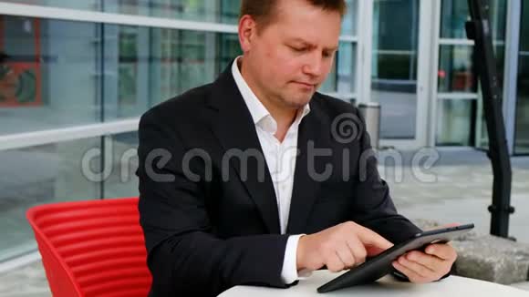 年轻自信的商人拿着平板电脑在外面视频的预览图
