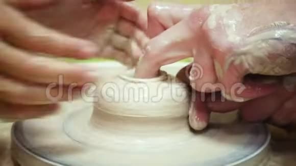 大人和小孩的手在做陶罐视频的预览图