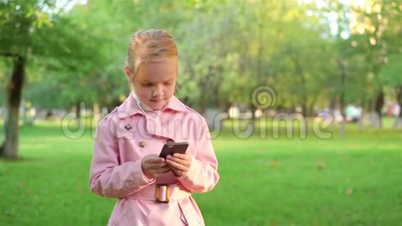 小女孩在公园散步时发短信视频的预览图