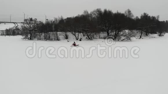 在冰冻的河流上乘雪车的空中景色开雪车在白雪上行驶视频的预览图