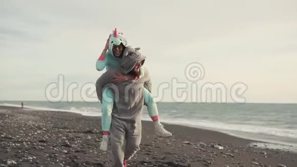 穿着吉古鲁米服装的幸福配偶在海边的一片石滩上奔跑视频的预览图