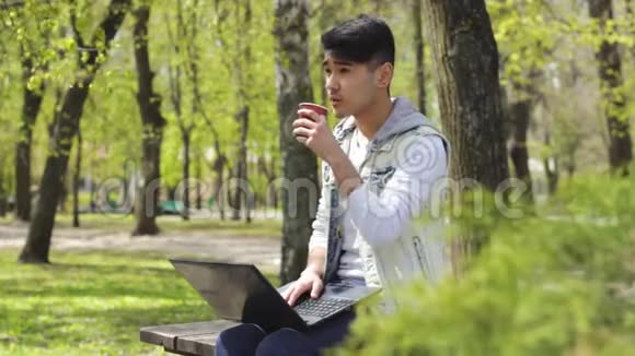 亚洲男子自由职业者在公园喝咖啡视频的预览图