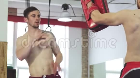 肌肉踢拳击手在踢垫上赤膊上阵视频的预览图