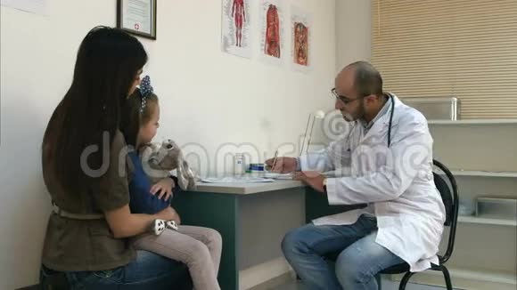 儿科医生填写医疗表格并给母亲和她的小女儿吃药视频的预览图