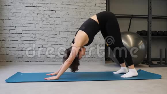 瑜伽垫年轻的运动女性伸展臀部腿筋肌肉腿部肌肉在健身房伸展运动视频的预览图