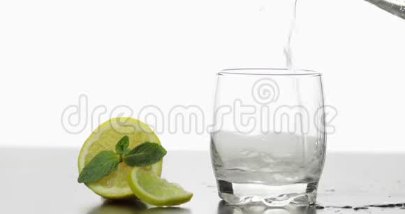 在杯子里倒入一杯冷饮里面有薄荷石灰柠檬和冰块视频的预览图
