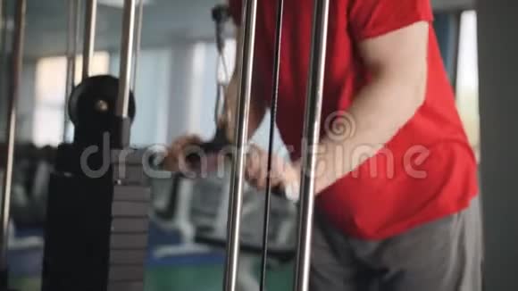 男子在健身房做体重锻炼4k视频男性训练手臂三头肌使用电缆机进行身体质量工作安排视频的预览图