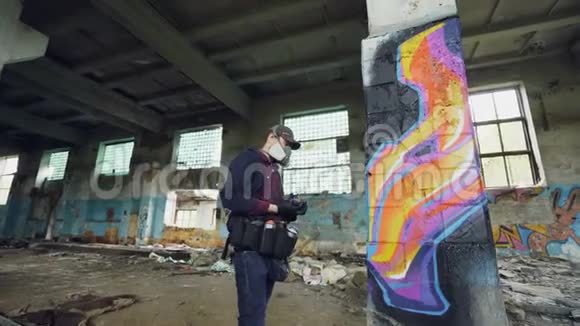 城市街头艺术家正在废弃的建筑里用肮脏的墙壁和窗户涂鸦他正在使用喷漆视频的预览图