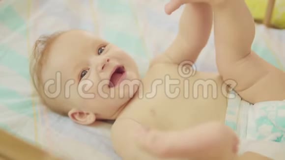 美丽的新生儿躺在背上看着镜头微笑着视频的预览图
