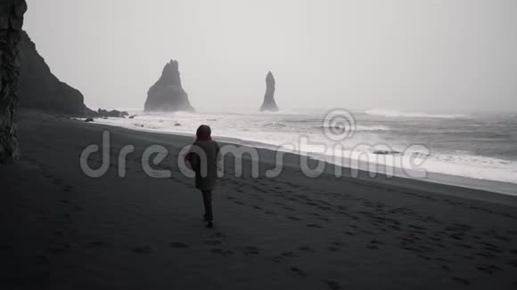 一个女孩正沿着荒芜的海滩散步视频的预览图