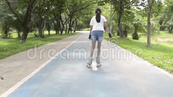 亚洲可爱的女孩在公共公园的路上玩滚轮刀视频的预览图