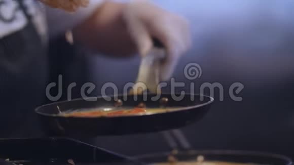 在锅上用黑色煎锅准备炒鸡蛋视频的预览图