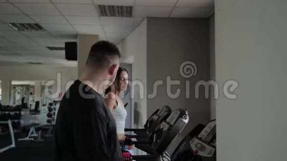 美丽的运动女性和超重的男性正在跑步机上训练视频的预览图