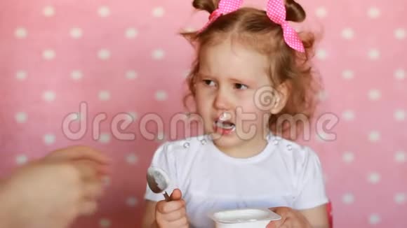 一个小女孩不想让母亲喂她但她想自己吃酸奶视频的预览图