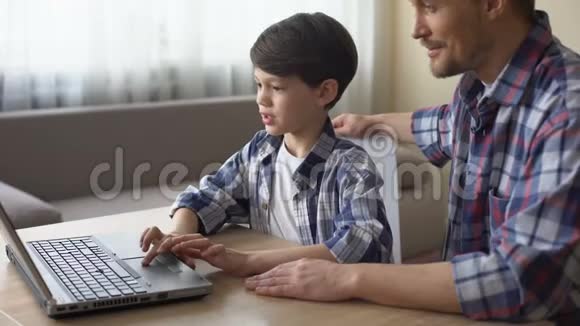 骄傲的父亲和儿子在笔记本电脑上网上购物科技视频的预览图