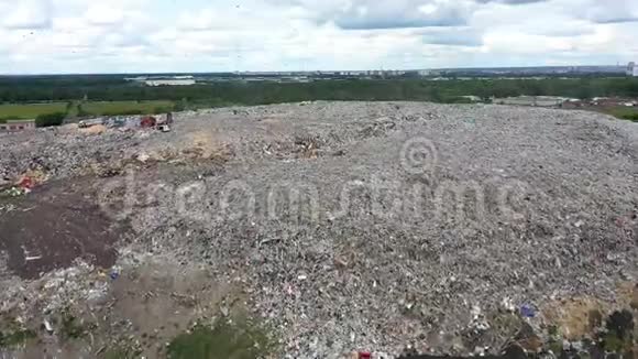 城市垃圾场工作垃圾的车辆和人员以食物垃圾为食的鸟飞过去空中景色视频的预览图
