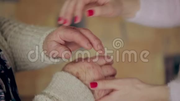一只年轻的手触摸并握住一只老皱的手孙女牵着祖母手视频的预览图