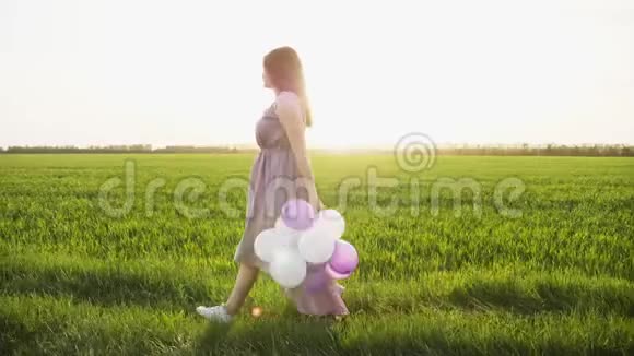 美丽的女孩带着五颜六色的气球在春田散步视频的预览图