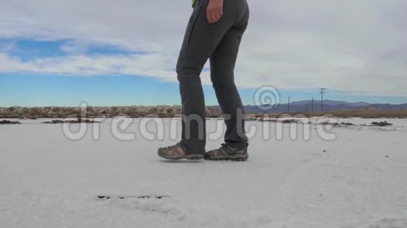 在沙漠的白盐面上行走的女人停着盐品尝视频的预览图