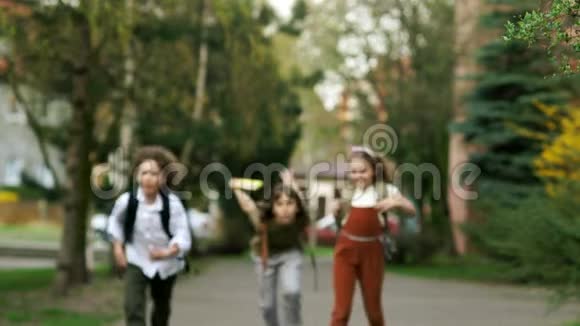 孩子们男孩和女孩从学校跑出来挥舞着背包有趣的假期回学校去儿童日视频的预览图